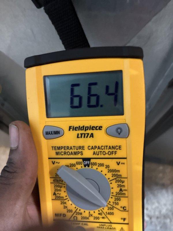 Completed A/C only installation with final system commissioning and verification. System electrical parameters were measured and confirmed within manufacturer specifications, with temperature readings of 52.2°F and 66.4°F recorded using calibrated test equipment to verify proper refrigerant charge and system performance.