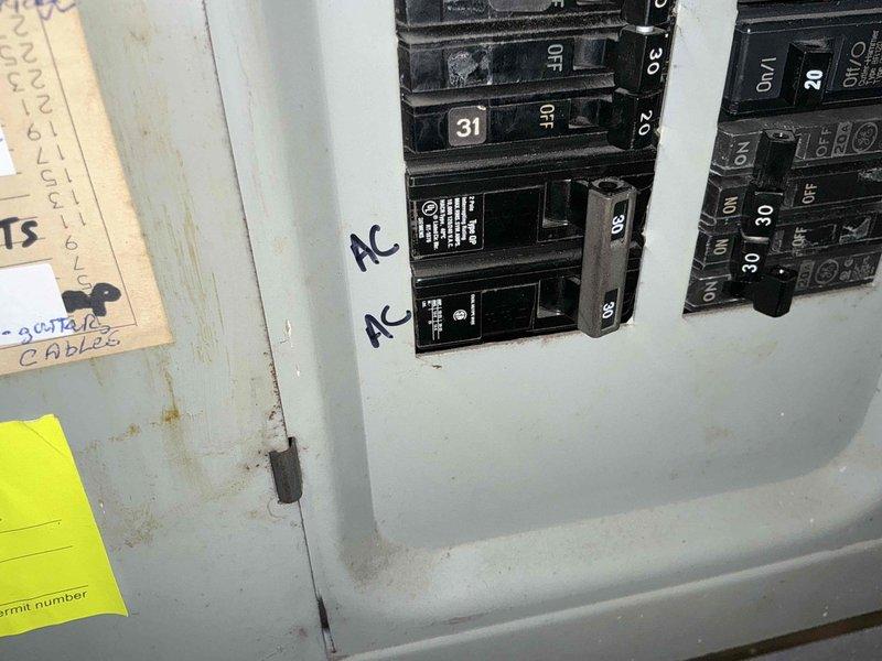 Conducted estimate consultation for air conditioning system replacement. Evaluated existing 25-year-old unit that has reached end of service life and presented replacement options to customer. Documented current electrical panel configuration showing dedicated AC circuit breakers for future installation planning.