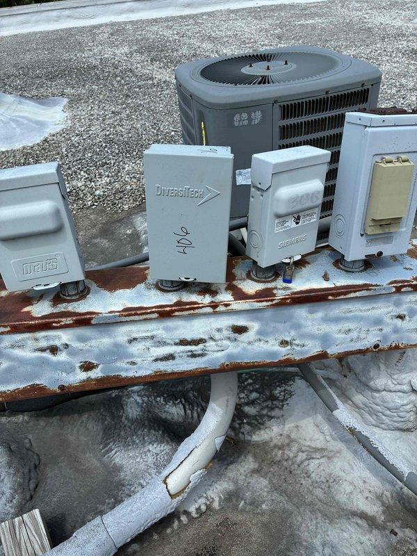 Responded to service call for non-operational air conditioning unit. Upon inspection, found rooftop commercial HVAC condenser with significant rust corrosion on mounting platform and electrical component housings, along with heavily weathered fan assembly showing oxidation on protective grille and central hub. Assessed electrical disconnects including Mars, DiversiTech, and Siemens components for proper operation and connections, verified condenser fan motor functionality, and restored unit to operational status.