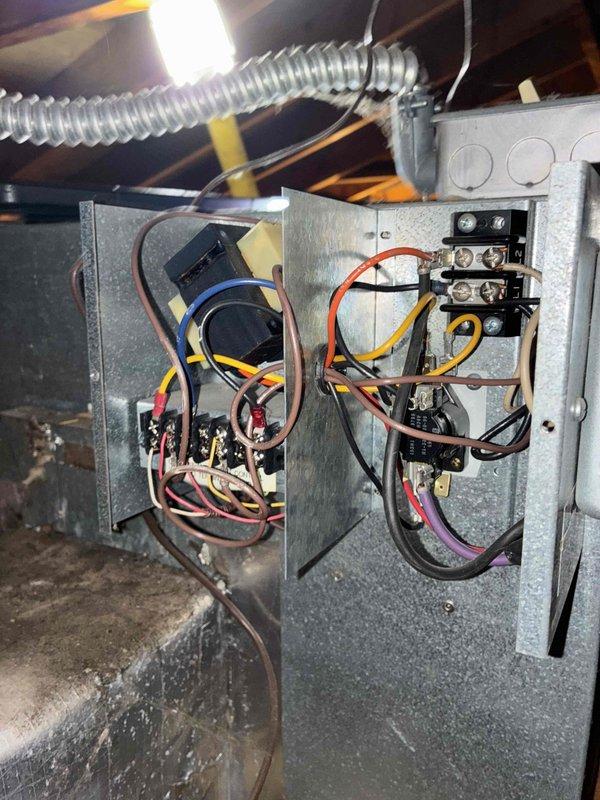 Completed cooling season tune-up on Unico high-velocity HVAC system. Inspected blower wheel assembly and housing, noting accumulated dust and debris on interior surfaces; verified electrical connections at control panels and contactors in attic installation. All system components operational and ready for continued service.
