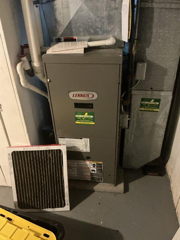 Responded to no cooling call affecting entire residence. Upon arrival, inspected Lennox furnace and air conditioning system located in basement mechanical room. Verified thermostat operation showing 72°F set point with system calling for cooling. Checked air filter condition and found filter accessible for inspection. System components including furnace, air handler, and associated PVC condensate drainage piping visually assessed for proper installation and connections. Thermostat displaying proper communication with HVAC equipment and responding to temperature adjustments in cooling mode.