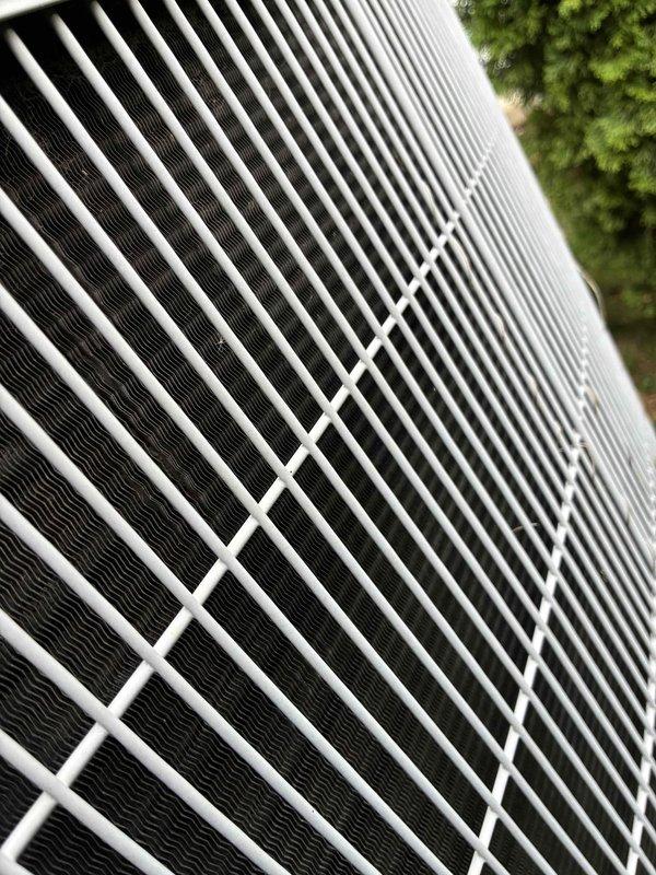 Completed routine cooling system maintenance on outdoor condenser unit as part of recurring preventive maintenance program. Inspected condenser coils, protective grille, and external components, confirming all elements in good operational condition with no visible damage or debris obstruction. Documented equipment condition with photographic records showing clean, properly functioning cooling fins and intact protective housing.