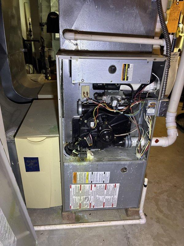 Conducted comprehensive assessment of existing 20-year-old HVAC system for full replacement estimate. Inspected furnace unit with exposed blower motor assembly and internal components, documented air handler configuration with ductwork connections and refrigerant lines, and evaluated overall system condition to provide accurate replacement recommendations for complete heating and cooling system upgrade.