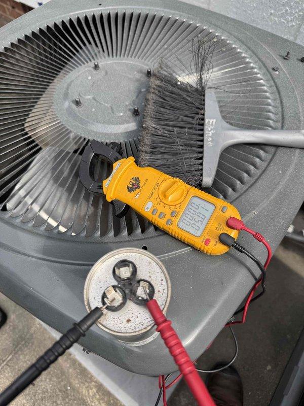 Responded to no cooling complaint on dual AC system. Performed diagnostic testing on both outdoor condenser units using digital clamp meter to measure electrical values and capacitor function. Cleaned condenser coils and verified component operation on both units to restore proper cooling performance.