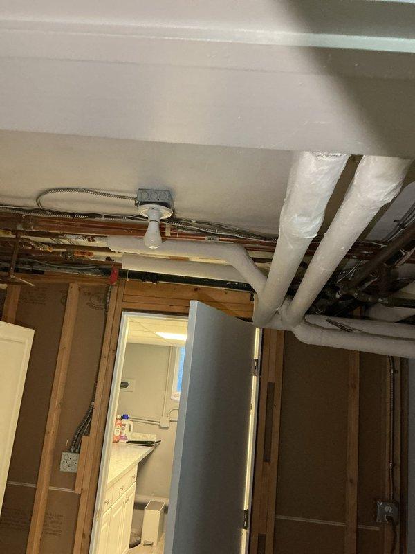 Responded to service call for damaged outdoor outlet and sauna electrical service requirements. Conducted site assessment and documented existing electrical panel configuration and basement utility area conditions. Inspected Panel 2 circuit directory showing multiple branch circuits serving various loads including laundry equipment, basement outlets, heating cables, and general lighting circuits. Evaluated unfinished basement space with exposed joists, existing electrical conduit runs, and mechanical infrastructure to determine feasibility for additional sauna circuit installation and outdoor outlet repair work.