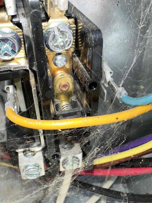 Completed cooling system tune-up and maintenance inspection. Upon accessing the unit, discovered extensive cobweb and dust accumulation throughout electrical components, terminal blocks, and pressure gauge assemblies. Thoroughly cleaned all electrical connections, terminal blocks, brass fittings, and surrounding components to restore proper airflow and prevent potential electrical issues. Verified all wire connections remain secure and properly terminated across yellow, blue, purple, and red conductors. System operational following maintenance service.