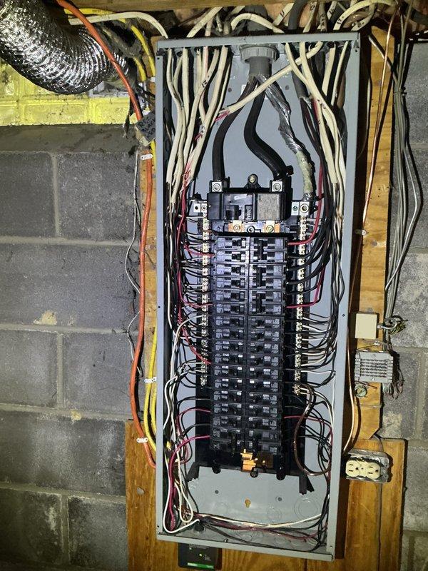Completed comprehensive electrical service repair involving HVAC system integration and main electrical panel work. Addressed electrical connections at HVAC component mounted on wooden substrate, securing multiple circuit wires including line voltage conductors and ground connections to system control panel. Serviced main electrical distribution panel containing dual main breakers and approximately 30-40 branch circuit breakers, ensuring proper wire terminations and circuit organization throughout the two-column breaker arrangement. Verified all electrical connections at panel including incoming service conductors and outgoing branch circuits in various wire gauges, confirmed proper grounding and bonding connections, and ensured all safety devices were functioning correctly.