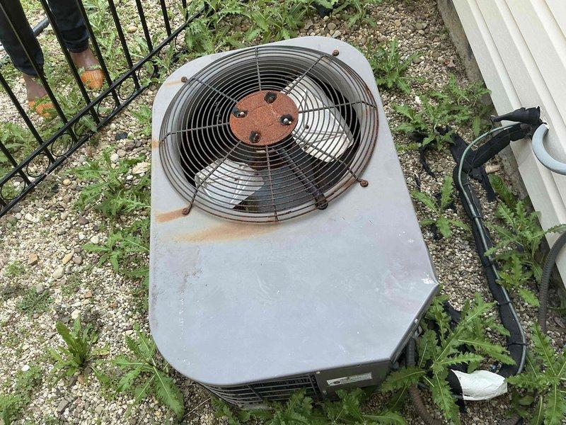 Technician responded to customer request for full HVAC system replacement options due to aging equipment. Upon arrival, conducted thorough assessment of existing outdoor condensing unit, which exhibited extensive deterioration including severe rust corrosion on fan hub assembly, mounting hardware, and cabinet surfaces. Unit showed significant weathering with rust streaking, faded paint, and overall wear consistent with extended service life beyond recommended replacement interval. Refrigerant lines and electrical conduit were inspected and documented. Site conditions noted vegetation encroachment around equipment pad and deteriorated gravel base. Comprehensive photographic documentation captured to support replacement proposal, including detailed images of corroded fan assembly, rusted cabinet components, and overall system condition. Prepared complete system replacement estimate with equipment options appropriate for customer's needs and property requirements.