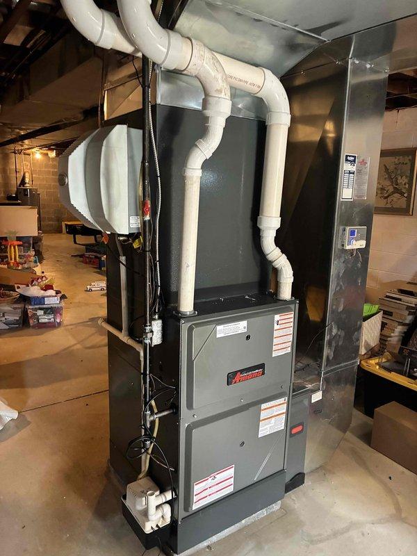 Completed full HVAC system installation including a 96% efficiency Amana furnace, air conditioning unit, and air scrubber system in basement location. Installed new digital programmable thermostat with backlit display, routed white PVC venting from furnace through ceiling joists, and connected all electrical wiring and ductwork to existing plenum system. System tested and operational at completion.