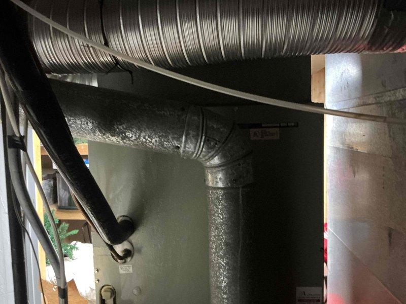 Responded to service call for 33-year-old Trane heating system with failed blower motor. Conducted comprehensive assessment of existing HVAC equipment located in basement utility area. Evaluated current system condition, noting age of equipment and operational failure. Documented installation including flexible aluminum ductwork, insulated vertical duct sections, and supporting infrastructure. Observed significant condensation on flexible ductwork indicating potential humidity issues or temperature differentials. Provided customer with detailed estimate options comparing blower motor replacement versus complete system replacement, discussing benefits and considerations of each approach given the age and condition of the existing equipment.