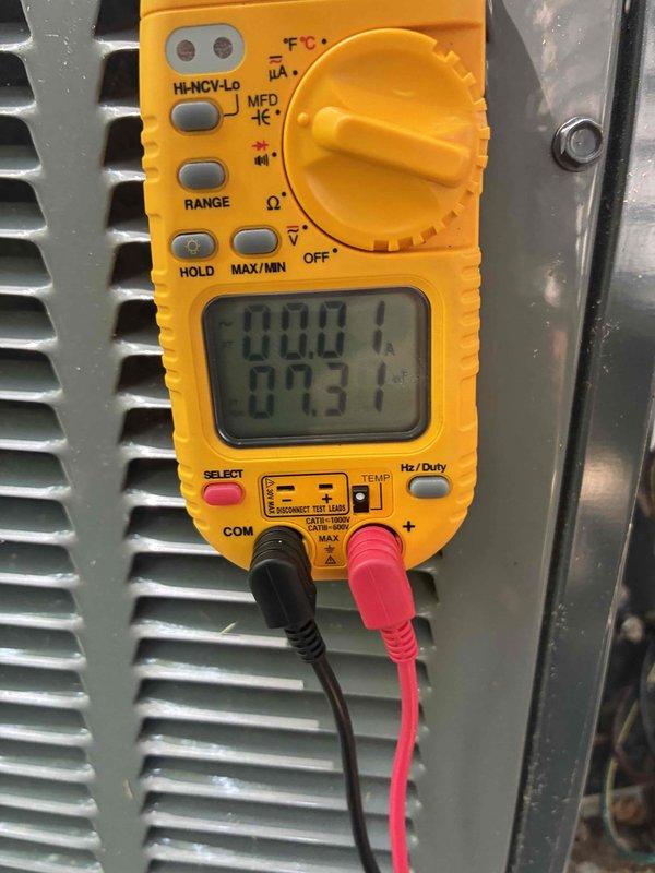 Completed comprehensive cooling season tune-up on residential HVAC system, including inspection of outdoor condensing unit and electrical disconnect box. Performed diagnostic testing with digital multimeter, verifying proper voltage and temperature readings, with system operating within normal parameters at 73.1°F.