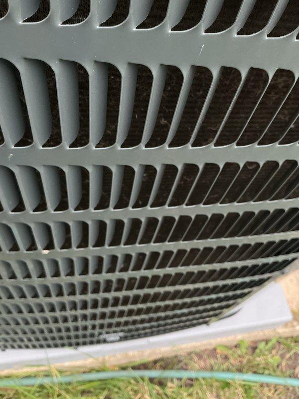 Completed routine HVAC cooling system maintenance on outdoor condensing unit. Inspected exterior condenser coil guard, louvers, and protective mesh screening, confirming all components were clean and in proper working condition with adequate airflow capability.