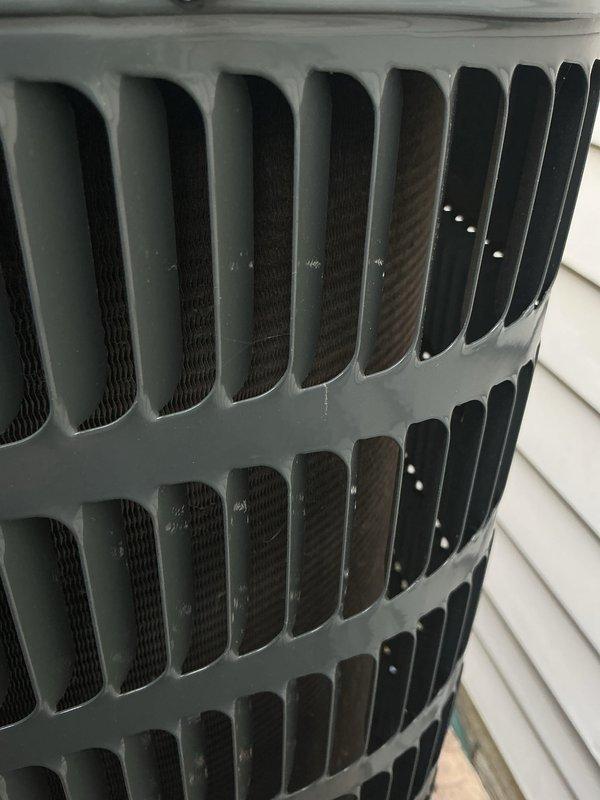 Completed routine HVAC cooling system maintenance on outdoor condensing unit. Inspected exterior condenser coil guard, louvers, and protective mesh screening, confirming all components were clean and in proper working condition with adequate airflow capability.