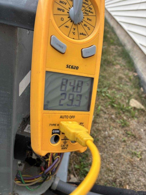 # HVAC Service Call - No Cooling Issue

Responded to service call for air conditioning unit running but not producing cool air. Upon arrival, performed diagnostic testing on outdoor condensing unit. Removed access panel to inspect internal electrical components and wiring connections.

Used digital multimeter to test capacitor functionality, recording measurements of 99.0 and 29.9 MFD. Connected manifold gauge set with refrigerant hoses to service ports to check system pressures and diagnose cooling failure. Tested electrical connections and voltage readings at compressor and fan motor terminals using clamp meter.

Based on diagnostic findings from capacitor testing and system pressure readings, identified root cause of no cooling condition. Completed necessary repairs to restore system operation and proper cooling performance. Verified all electrical connections secure and system operating within normal parameters before closing access panel and completing service call.