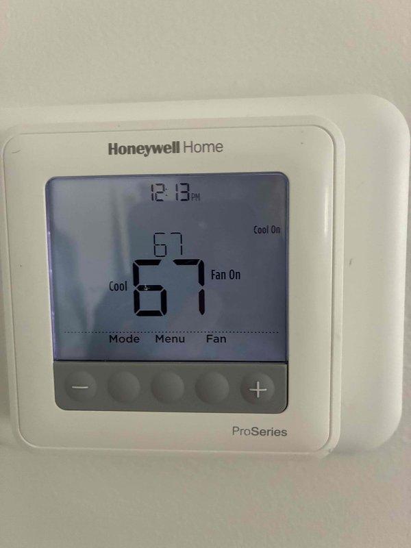 Responded to service call for air conditioning unit not cooling and leaking. Upon inspection, found excessive condensation on supply ductwork in attic space, indicating inadequate insulation and possible airflow issues. Thermostat displayed 61 degrees with cooling cycle actively running. Observed moisture accumulation on flexible ductwork with multiple areas of tape repair, suggesting long-term condensation problems and compromised duct integrity that may be contributing to reduced system efficiency and cooling performance.