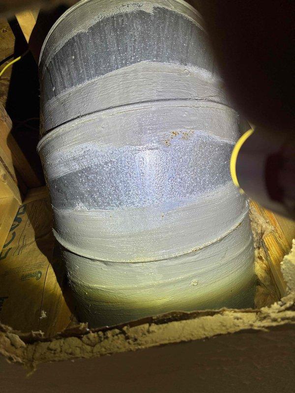 Responded to service call for air conditioning unit not cooling and leaking. Upon inspection, found excessive condensation on supply ductwork in attic space, indicating inadequate insulation and possible airflow issues. Thermostat displayed 61 degrees with cooling cycle actively running. Observed moisture accumulation on flexible ductwork with multiple areas of tape repair, suggesting long-term condensation problems and compromised duct integrity that may be contributing to reduced system efficiency and cooling performance.