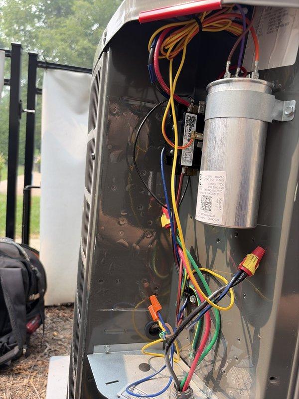 Completed comprehensive cooling season tune-up on residential outdoor condensing unit. Performed electrical diagnostics using clamp meter to verify proper amperage draw on compressor and condenser fan motor, inspected capacitor and all electrical connections for proper operation, and documented equipment condition through detailed photography. All components found operating within normal parameters with wiring connections secure and unit functioning properly for continued cooling season operation.
