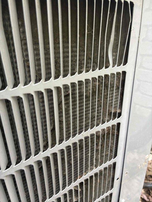 # HVAC Cooling Maintenance - Two System Service

Completed comprehensive preventive maintenance service on two cooling systems as part of ongoing recurring maintenance program. Performed thorough inspection of both units, including examination of condenser coils, heat exchanger components, and airflow pathways. 

First system inspection revealed stock unit #813 with proper airflow direction labeling intact. Noted moderate corrosion present on metal framework and support structures, consistent with normal aging and environmental exposure. Heat exchanger fins and ribbed components inspected and found operational, though frame deterioration documented for monitoring.

Second unit presented with significant dirt accumulation and debris buildup on exterior grille and louvers. Dark streaking and grime visible throughout horizontal slat assembly, with concentrated soiling in airflow channels. Condenser coils behind grille showed dust and debris infiltration. External housing mounted on buildi