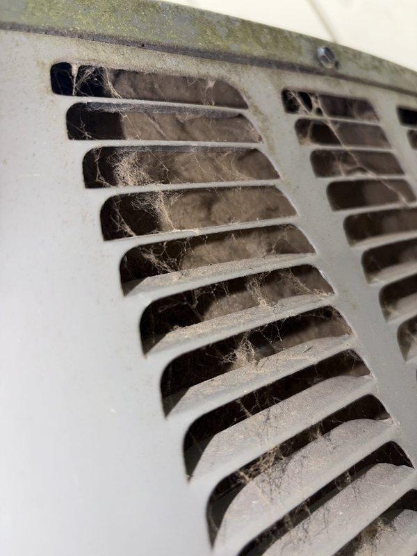 Completed scheduled preventative maintenance on residential cooling system. Upon arrival, found significant dust and debris accumulation on ventilation grille with visible cobwebbing and possible mold growth, indicating extended period without service. Thoroughly cleaned all accessible components and tested system capacitance readings using digital multimeter, confirming proper electrical function at 44.65 μF. Unit restored to optimal operating condition.