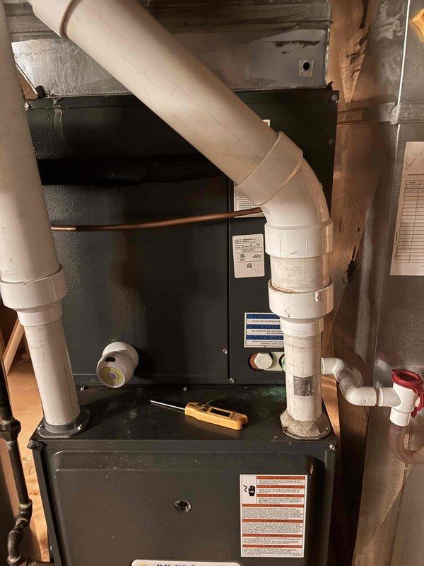 Completed routine HVAC cooling maintenance on residential system. Inspected indoor furnace unit with high-efficiency condensing setup, verified proper operation of intake and exhaust PVC venting, and examined outdoor condenser unit. All components found to be functioning within normal parameters with no immediate service needs identified.