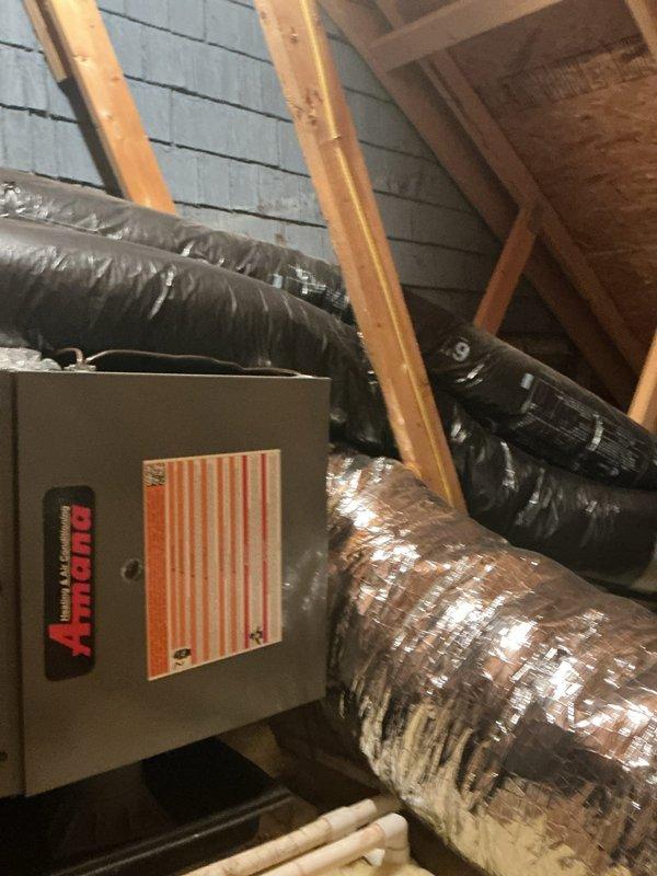 Responded to report of mold on ceiling near attic crawl space access point in closet of addition section. Accessed attic crawl space using ladder to inspect one-year-old Amana heating unit and heat exchanger for suspected water leak. Upon inspection, confirmed HVAC system and ductwork installation in attic space with flexible silver-insulated air ducts and control unit properly mounted. Examined heat exchanger and surrounding areas for signs of active leakage or condensate drainage issues that could be contributing to ceiling moisture and mold growth. Documented equipment condition and attic installation with photos showing system components and affected areas. Advised homeowner of findings and recommended next steps for remediation.