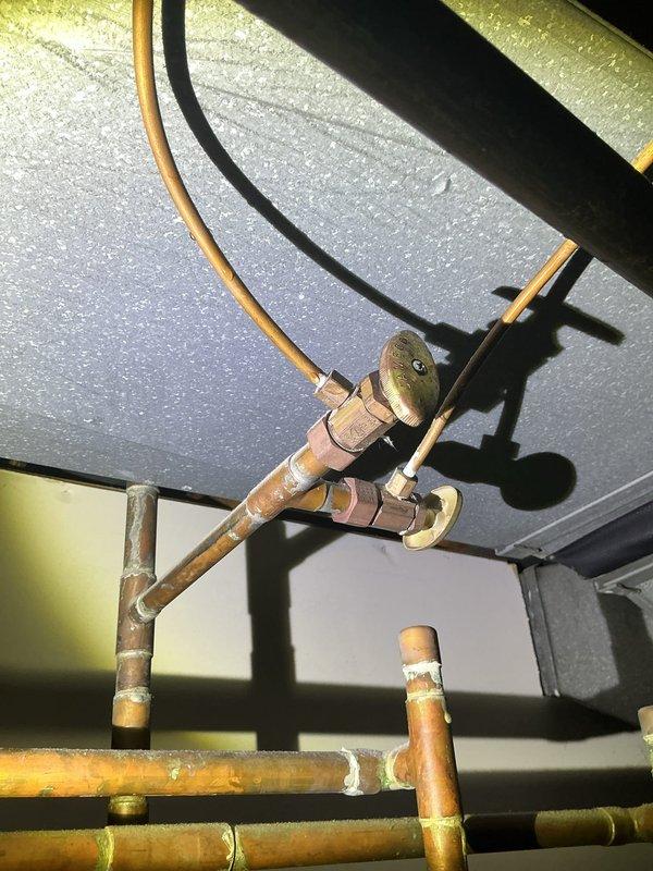 Responded to water leak in basement originating from furnace area as confirmed by city department inspection. Upon arrival, inspected copper piping, tubing connections, and valve fittings in the mechanical space. Observed aging copper components with visible patina, mineral deposits, and corrosion on brass fittings. Examined condensate drainage system and plumbing connections beneath furnace unit, including PVC drain line and associated copper tubing. Documented conditions of all piping infrastructure and connection points for assessment and future reference.