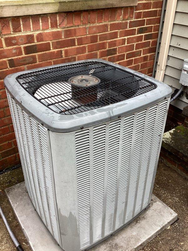 Completed seasonal cooling system tune-up on residential air conditioning unit. Performed comprehensive inspection of outdoor condenser unit, checked refrigerant levels, cleaned coils, tested electrical connections at weathered disconnect box, verified proper airflow through louvers, and confirmed system operation within manufacturer specifications. Unit showed age-related wear but maintained functional performance throughout diagnostic testing.
