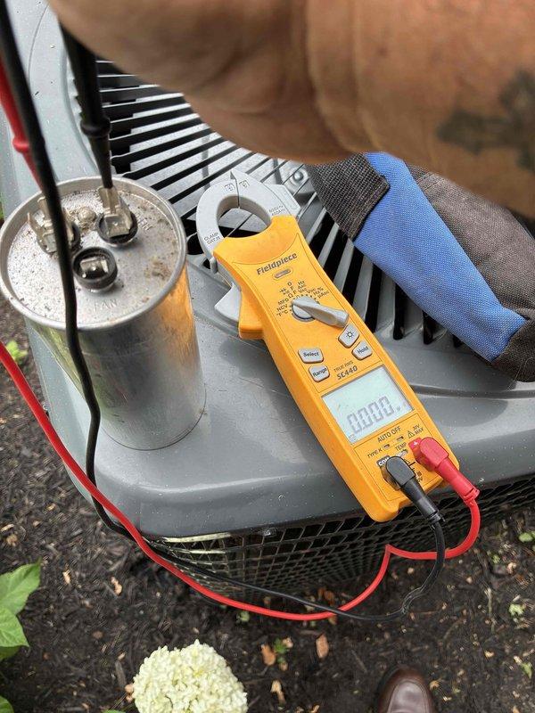 Performed diagnostic testing on outdoor A/C unit and replaced failed run capacitor. Used digital multimeter to verify electrical readings and confirm proper system operation after component replacement.