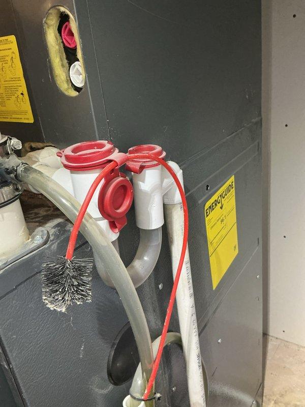 Completed routine HVAC cooling maintenance on residential system, performing standard inspection of furnace unit and associated components. Verified proper operation of condensate drain system with U-trap configuration, checked refrigerant lines and connections, and confirmed all safety labels and equipment specifications were clearly visible and intact.