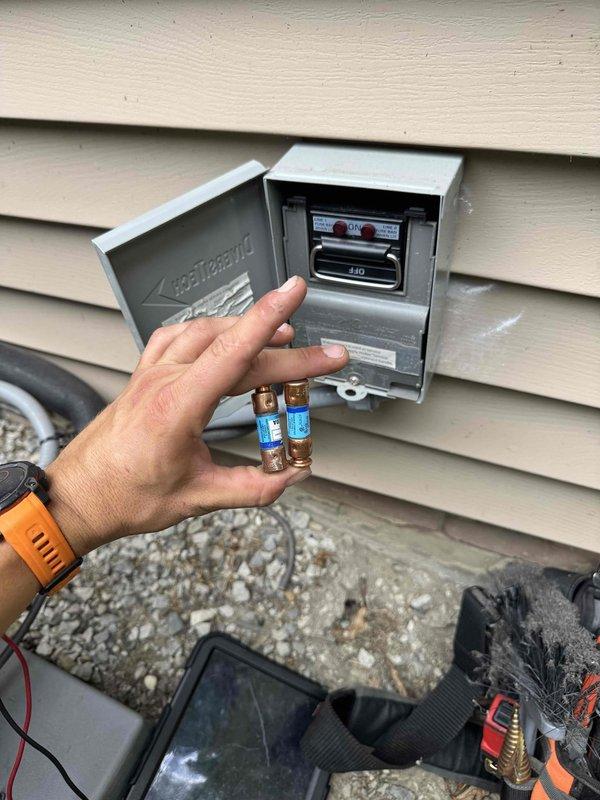 Responded to no-cooling call on one-year-old Daikin outdoor unit. Found red fault indicator illuminated at exterior disconnect box indicating blown fuse. Diagnosed failed fuse preventing power to condensing unit. Replaced defective fuses in outdoor disconnect, verified proper amperage rating per manufacturer specifications, restored power to system, and confirmed unit operation with normal cooling restored.