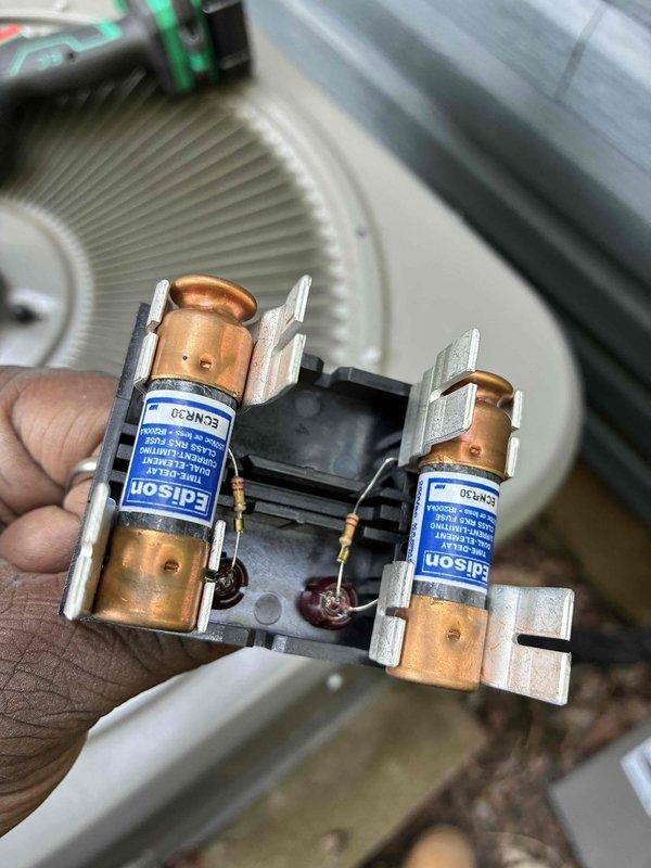 Completed scheduled cooling system maintenance on residential HVAC unit. Inspected and tested electrical components including dual Edison ECNR 30 amp fuses, which showed minor discoloration and burn marks at connection points but remained within operational parameters. Examined evaporator coil fins and heat exchanger assembly, noting oxidation and age-related discoloration on copper/aluminum fins while confirming adequate airflow through densely packed fin arrangement. All critical components operational and system returned to service.