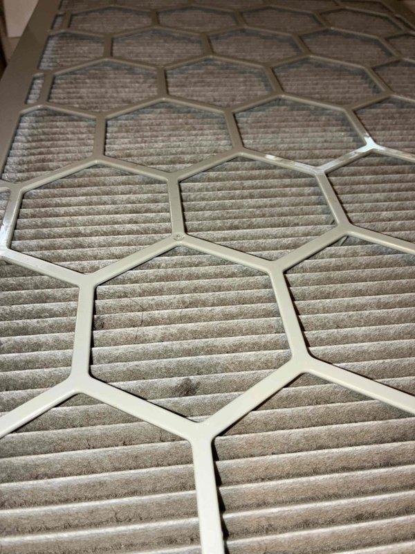 Responded to no cooling complaint on recently installed system. Upon inspection, found severely restricted airflow due to heavily soiled air filters with significant dust and debris accumulation. Removed and documented multiple hexagonal-frame pleated filters showing substantial contamination that was impeding system performance and preventing adequate cooling capacity.