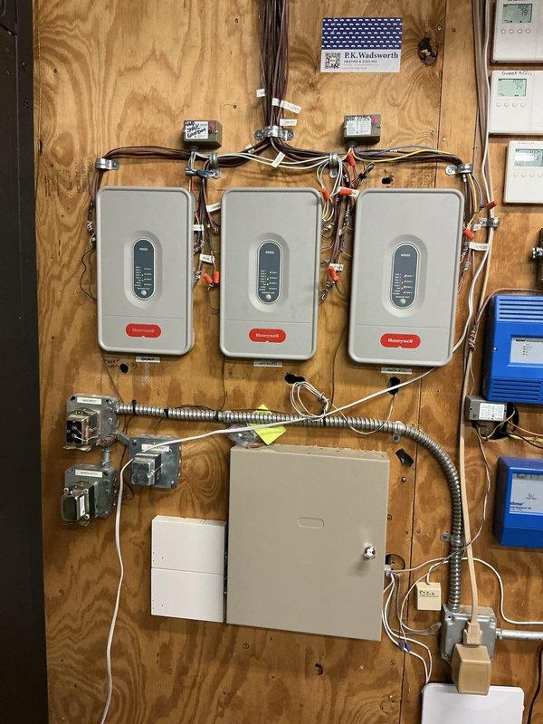 Responded to service call for non-operational upstairs air conditioning unit that had been inoperative for three weeks. Conducted comprehensive system evaluation and documented existing HVAC installation, including outdoor Trane condenser unit with proper mounting on concrete pad and river rock landscaping, electrical disconnect and control panel components, and indoor multi-zone control system featuring three Honeywell zone controllers with associated wiring and junction boxes. Presented replacement options to address the failed upstairs cooling system.