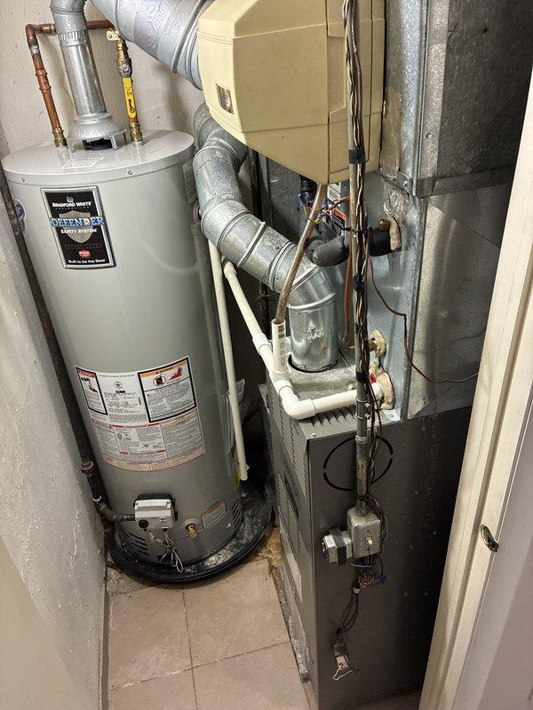 Completed HVAC equipment estimate for replacement of existing residential furnace system located in utility closet. Evaluated current beige furnace unit with exposed internal components including compressor assembly and gas valve connections. Provided customer with options for Lennox high-efficiency replacement unit to upgrade from current equipment. Documented existing installation configuration including ductwork connections, electrical wiring, and proximity to water heater for accurate replacement planning and sizing requirements.