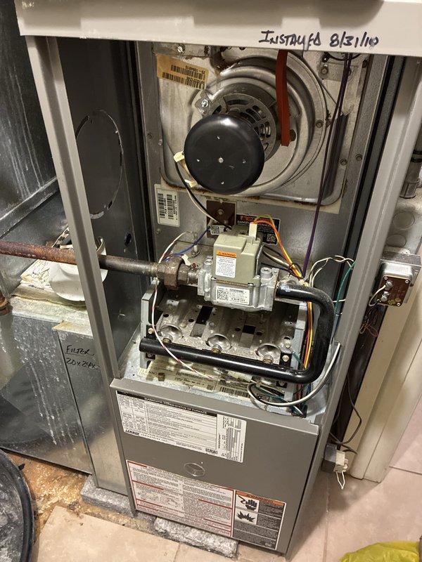 Completed HVAC equipment estimate for replacement of existing residential furnace system located in utility closet. Evaluated current beige furnace unit with exposed internal components including compressor assembly and gas valve connections. Provided customer with options for Lennox high-efficiency replacement unit to upgrade from current equipment. Documented existing installation configuration including ductwork connections, electrical wiring, and proximity to water heater for accurate replacement planning and sizing requirements.