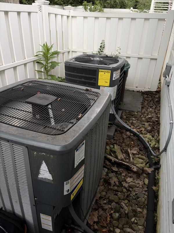 Completed scheduled maintenance on dual outdoor air conditioning systems, both over 10 years old. Performed comprehensive inspection of both condenser units, including visual assessment of exterior cabinets, refrigerant line connections, electrical conduit, and mounting stability. Measured and recorded system temperatures, with indoor equipment reading 58.0°F at the air handler. Inspected electrical connections and wiring at both outdoor and indoor components. Noted units operating with accumulated debris around base and dust accumulation on indoor equipment housing. Both systems functional at time of service completion.