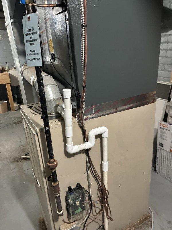 Completed installation of new Goodman air conditioning system including outdoor condensing unit positioned on concrete pad against building exterior. Installed metal conduit line set connecting outdoor unit to existing indoor air handler, with all electrical connections properly terminated and secured to building structure. System tested and confirmed operational upon completion.