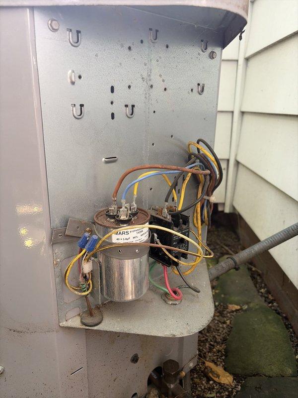 # HVAC Cooling System Maintenance - MVP Service

Performed comprehensive preventive maintenance on an aging outdoor cooling system unit. Conducted thorough inspection of electrical components housed within the exterior-mounted control panel, including the MARS capacitor and Homeis HN51KC024 contactor. 

Evaluated all electrical connections and wiring integrity, noting age-appropriate wear on conductor insulation. Verified proper terminal connections on the 24VAC coil contactor and capacitor assembly. Assessed mounting hardware and panel condition, which showed expected weathering consistent with outdoor installation and extended service life.

All critical electrical components were inspected and found to be operational. System electrical connections were secure and functioning within normal parameters. Unit cleared for continued operation following maintenance protocol completion.