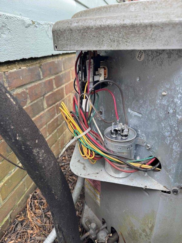 Responded to service call for loud whirring sound occurring at system startup on an 11-year-old air conditioning unit. Upon arrival, performed diagnostic inspection of outdoor condensing unit and associated electrical components. Inspected condenser fan motor, capacitor, and contactor assembly for signs of wear or failure that could cause the reported noise. Examined exterior electrical junction box and verified all wire connections were secure and properly terminated. Assessed ductwork seams and insulation for any loose components or vibration points that might contribute to startup noise. Documented equipment condition with photographs showing electrical connections at outdoor unit and ductwork installation. Based on the age of the system and symptom presentation, likely causes include worn condenser fan motor bearings, failing start capacitor, or loose mounting hardware creating vibration during initial startup cycle.