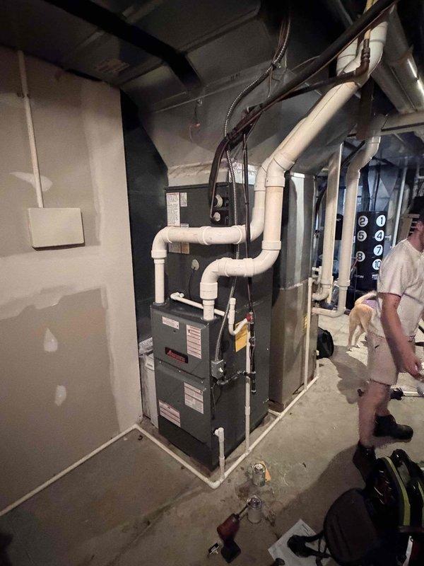 Completed full HVAC system installation including 96% high-efficiency gas furnace in basement mechanical room and outdoor air conditioning condenser unit. Installed new furnace with proper PVC venting configuration, connected flexible ductwork to existing system, and ran electrical conduit to code. Mounted AC condenser on concrete pad against exterior brick wall with proper clearances, established refrigerant line set connections, and verified all electrical connections at disconnect box. System tested and operational with proper airflow and temperature differentials confirmed.