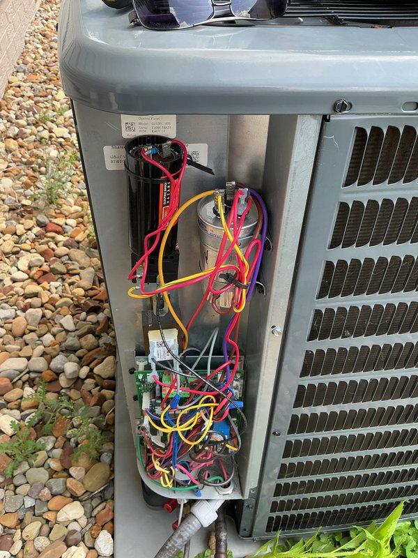 Responded to service call for 5-year-old air conditioning system experiencing recurring loss of cooling requiring breaker resets. Accessed outdoor unit electrical compartment and performed diagnostic evaluation of control boards, wiring connections, and capacitor. Reviewed fault code history and inspected internal electrical components including dual circuit boards, terminal connections, and capacitor mounting. System exhibited signs of potential electrical fault causing breaker trips, with disorganized wiring noted in compartment. Documented internal component conditions with photographs for diagnostic reference and recommended further electrical testing to identify root cause of chronic breaker tripping issue.