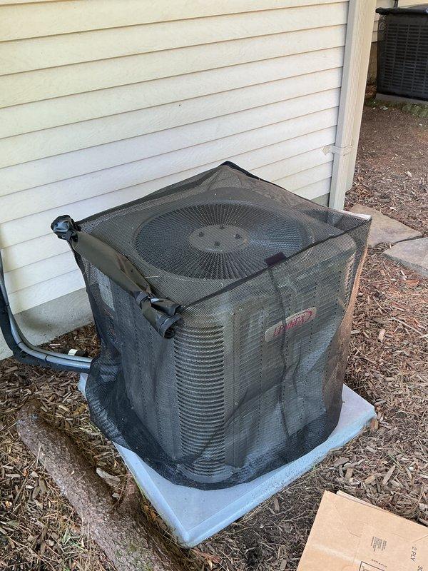 Performed comprehensive tune-up on outdoor condensing unit, removing protective cover and top panel to access internal components. Cleaned condenser coil of accumulated dirt and debris, removed significant buildup of grass clippings, pine needles, and organic material from unit base and around compressor. Inspected refrigerant lines, fan blade assembly, and electrical connections for proper operation and wear.