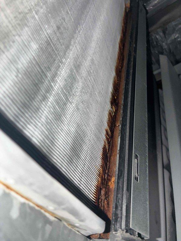 Completed air conditioning tune-up service as scheduled. Performed standard maintenance protocol including system inspection, filter check, and operational testing of cooling components. Documented existing exterior window frame corrosion and deterioration at service location for customer awareness, noting rust-colored oxidation along frame joints and track assembly showing moisture exposure and debris accumulation unrelated to HVAC equipment.