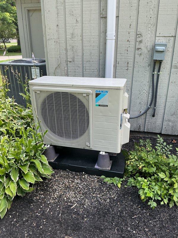 Replaced three deteriorated condenser pads for outdoor HVAC units, including an Amana air conditioning unit and a Daikin mini-split condenser system. Leveled and positioned new black rubber pads to ensure proper equipment support, drainage, and vibration isolation for all three units mounted on the building exterior.