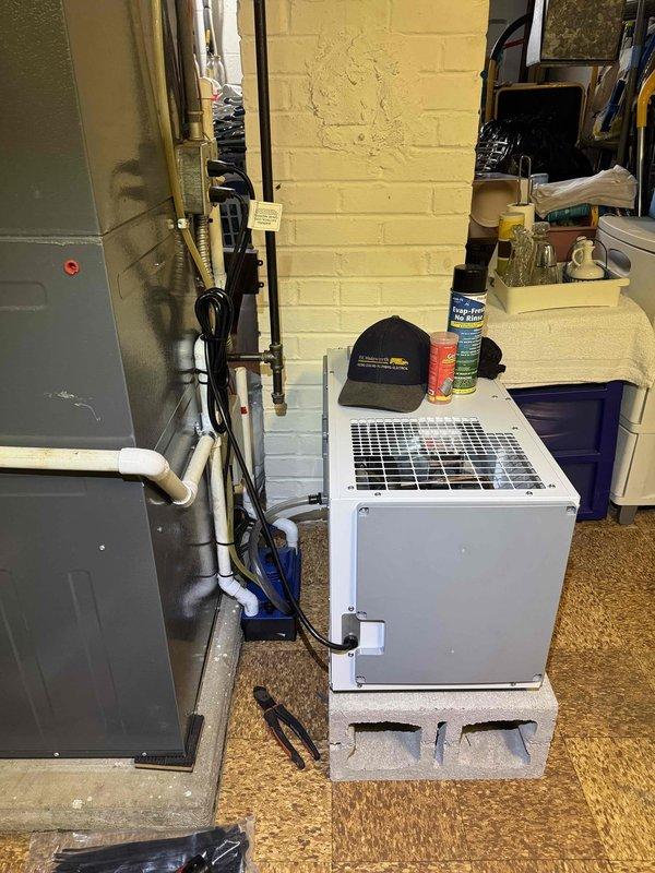 Installed whole home dehumidifier system in mechanical room, including mounting unit on concrete block platform, establishing electrical connections via dedicated circuit, and integrating supply and return ductwork with existing HVAC infrastructure. Completed all necessary condensate drain line connections using PVC piping to ensure proper moisture removal and system operation.