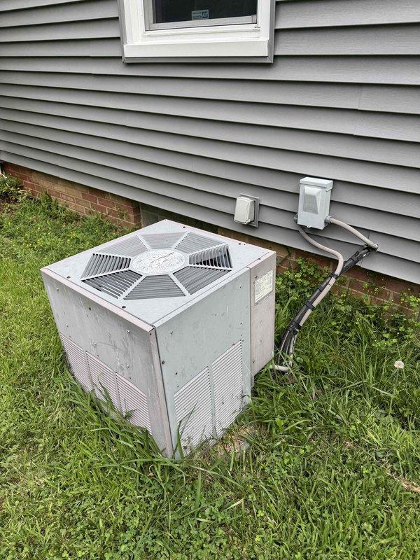 Completed annual cooling maintenance on 24-year-old Weatherking air conditioning system. Performed comprehensive tune-up including inspection of outdoor condenser unit, refrigerant lines, electrical connections, and all operational components. Cleared overgrown vegetation from around unit base and perimeter to ensure proper airflow and accessibility. Inspected condenser coils, fan motor assembly, and top grille protection system. Verified electrical conduit connections running to building exterior remain secure and properly mounted. Checked drainage system components visible near unit foundation. Unit operational and ready for continued service through 2026 maintenance cycle.