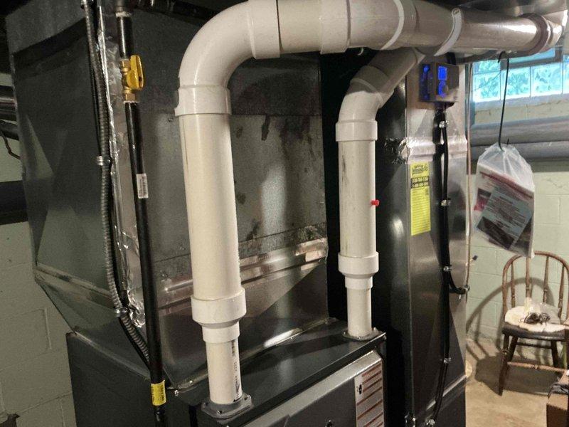 Conducted comprehensive assessment of existing 35-year-old HVAC system for complete replacement estimate. Evaluated current furnace and air conditioning equipment in basement utility area, documenting existing installation configuration including ductwork, condensate drainage system, gas connections, and thermostat controls. Photographed equipment specifications, existing PVC drainage piping, flexible ductwork connections, and programmable thermostat to determine appropriate replacement system sizing and compatibility requirements for full system upgrade proposal.