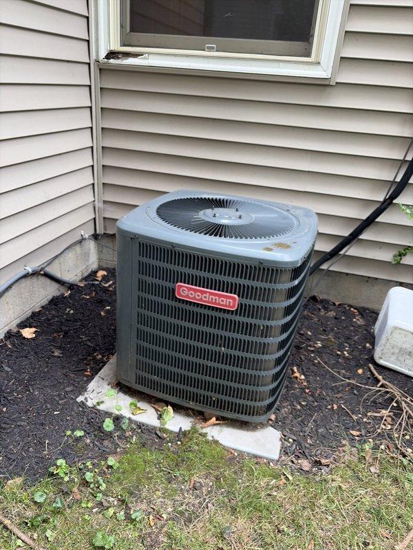Performed routine preventive maintenance on residential Goodman air conditioning system. Conducted visual inspection of outdoor condenser unit, verified proper operation, and obtained electrical measurements using clamp meter showing compressor amperage of 4.23A and capacitance reading of 0.081, indicating normal system performance. Unit found to be operating within manufacturer specifications with no deficiencies noted.