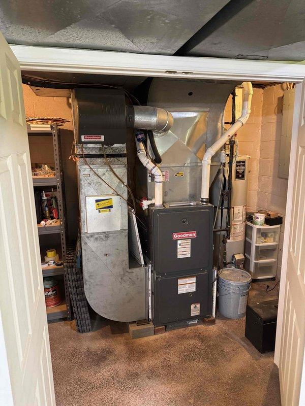 Responded to no cooling complaint following recent maintenance visit. Inspected Goodman air handler and blower assembly in basement utility room. Found blower wheel heavily contaminated with dust and debris accumulation, restricting airflow and preventing proper system operation. Cleaned blower wheel and housing, restoring normal airflow and cooling function.