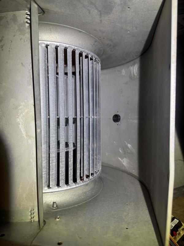 Responded to no cooling complaint following recent maintenance visit. Inspected Goodman air handler and blower assembly in basement utility room. Found blower wheel heavily contaminated with dust and debris accumulation, restricting airflow and preventing proper system operation. Cleaned blower wheel and housing, restoring normal airflow and cooling function.